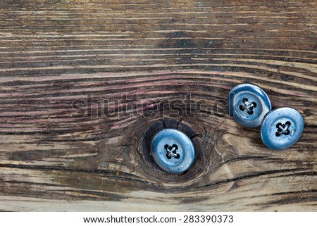 vintage buttons on the aged textured boards of the old tailor table