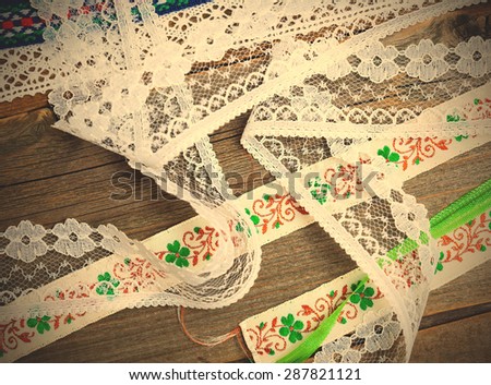 set of vintage lace, tape and ribbons on old surface of tailors table. instagram image filter retro style