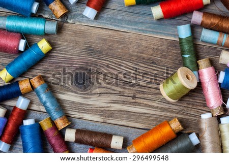 Vintage spools with colored threads on old tailoring table with copy space