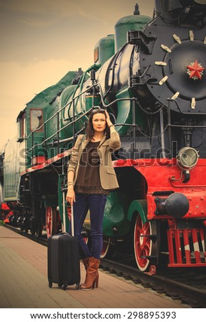 beautiful woman traveler with luggage near retro puffer. instagram image filter retro style