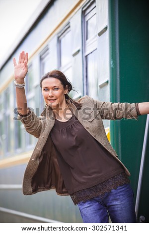 beautiful adult woman goes on a journey and goodbye, waving his hand