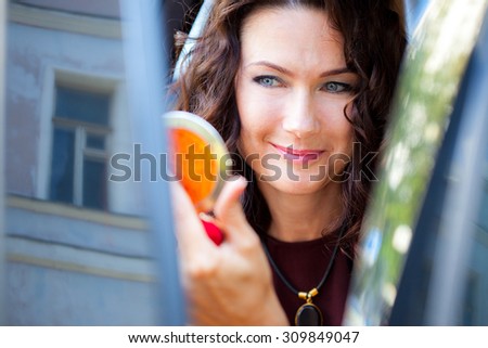 beautiful middle-aged woman looking at herself in the mirror and smiling