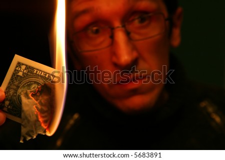 Dollar in Fire on Background of the Alarmed Person