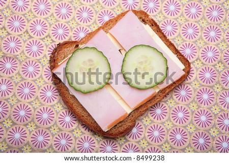 sandwich from pumpernickel bread with butter, ham and cucumber