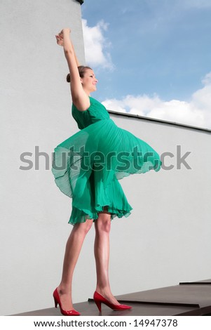 girl in green gown dances with wind