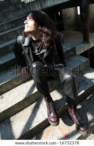man in the black leather cloth and high shoe warmed face on sun