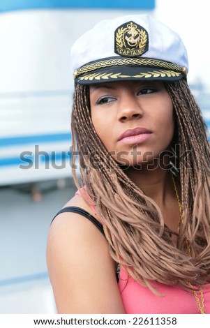 girl in red tanktop and captain cap on background of the motor ship