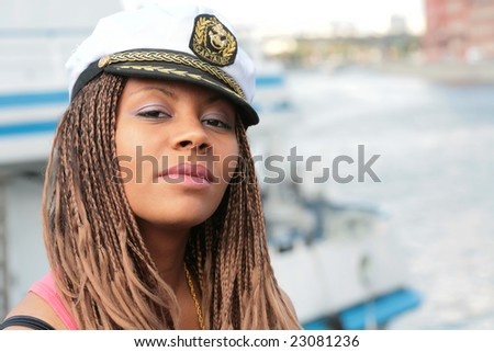 girl in captain cap on background of the motor yacht