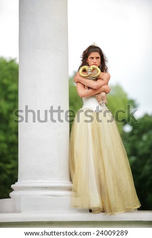 beautiful bride in white-golden dress with loved doll dreams of future