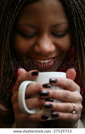 close-up portrait of the beautiful black woman with white mug in hand. small depth to sharpness