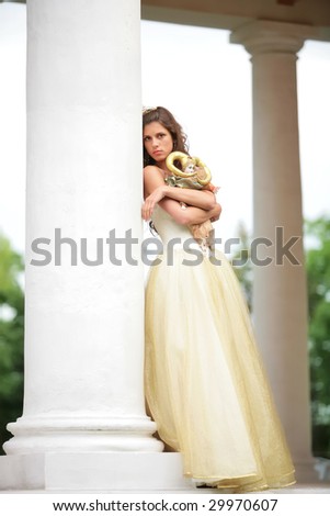 beautiful girl in white-golden dress with loved doll dreams of future
