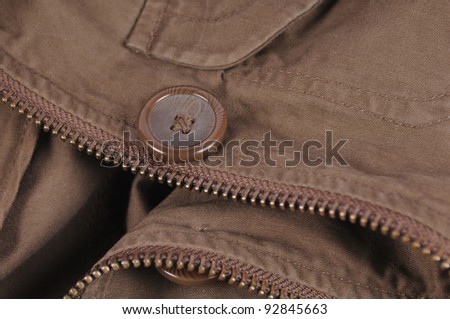 Brown cotton clothes closeup with big button and zipper