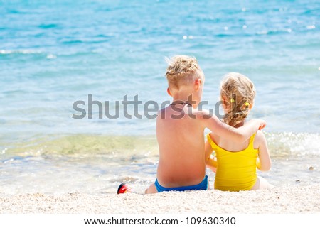 Happy brother and sister relaxing on the coast of the sea