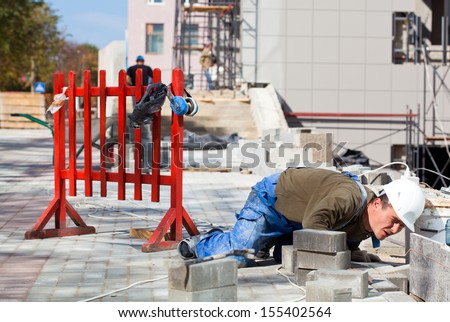 Tiler laborer monitoring quality of construction works during installation granite tiles