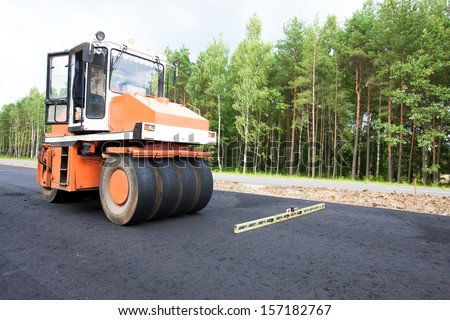 Road roller and water level during asphalt paving works