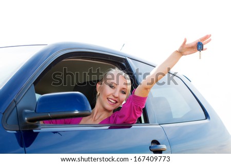 Happy blonde car driver woman showing new car keys in car window