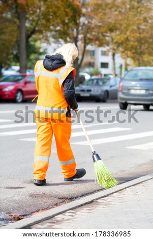 Road worker sweeper cleaning street with broom tool