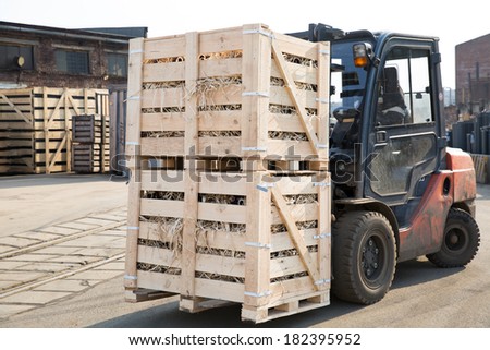 Factory Forklift Truck Stacker Transporting Wood Cargo Boxes with Products to Plant Warehouse