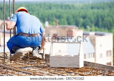 Construction worker with tool box mounting form work during concreting building floors