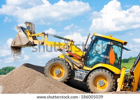 Wheel Loader Excavator unloading Gravel or Sand during Earth Moving Works at Construction Site