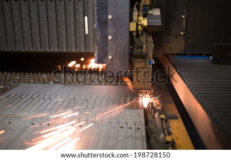 Industrial laser during cutting metal works in factory workshop