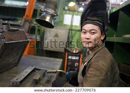 Asian industrial welder worker at factory workshop background
