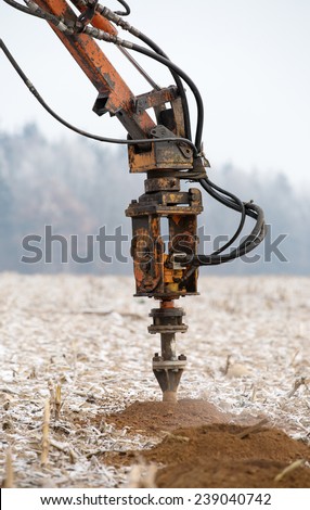 Drilling rig boring holes in ground during construction geodesy works