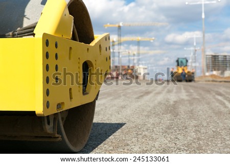 Road roller vibration machine compacting gravel base for asphalt pavement during construction roadworks