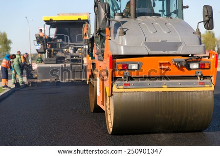 Road construction works with roller compactor machine and asphalt finisher