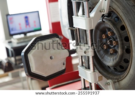 Car wheel with computerized alignment device at wheel and tire alignment service station