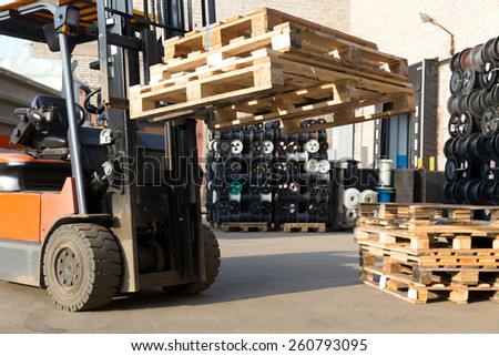 Factory Forklift Truck Stacker Transporting Pallets at Plant Warehouse