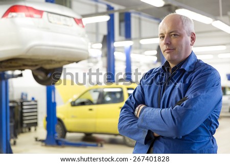 Caucasian mechanic service man worker on automobile garage repair station background