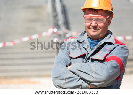 Adult construction male worker in uniform and safety glasses