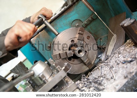 operator fixing workpiece in manual lathe machine chuck