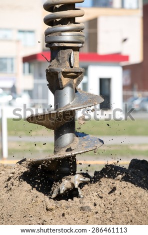 Drilling rig boring hole in soil at construction site
