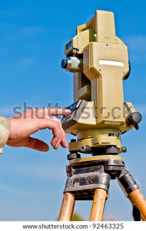 person hand making data input into survey equipment tool theodolite