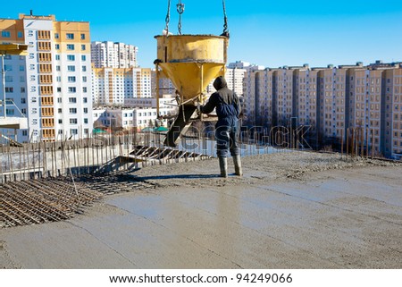 Construction worker pouring concrete during commercial concreting floors and building reinforced concrete structures