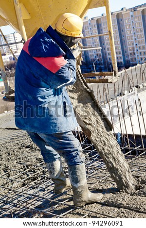 builder worker in hard helmet  and uniform during concrete pouring works at construction site