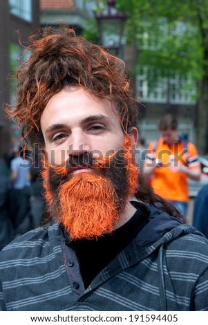 AMSTERDAM, THE NETHERLANDS, APRIL 26, 2014: Young man with an orange beard during the celebration of the first King\'s day (Koningsdag) to celebrate King Willem\'s birthday on April 26, 2014