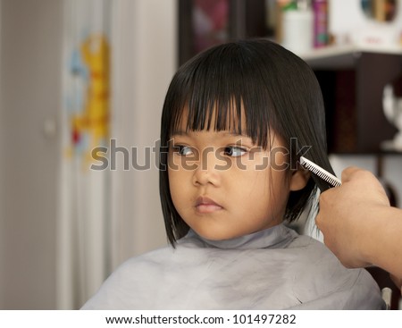 Cute young girl getting a haircut before back to school