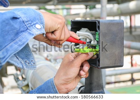 Technician use screwdriver tighten nut in junction box
