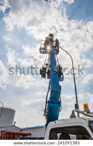 RAYONG , THAILAND , DECEMBER 26 - 2014 ; Electrical technician repairing street light by boom lift in industrial Plant at Rayong, Thailand