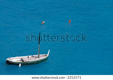 Boat floating on blue water. Space left intentionally blank for text