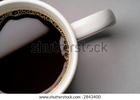 Coffee cup on grey background (seen from above) closeup