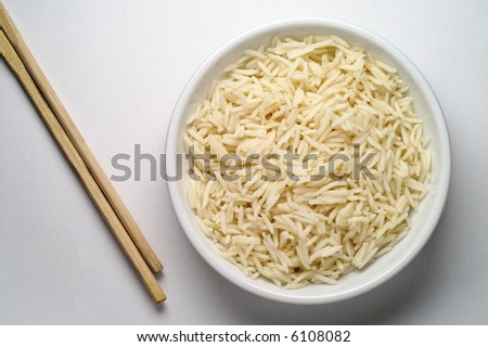 Dish of Basmati rice and chopsticks seen from above over white background