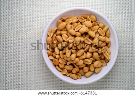Peanuts in a dish from above over linen tablecloth