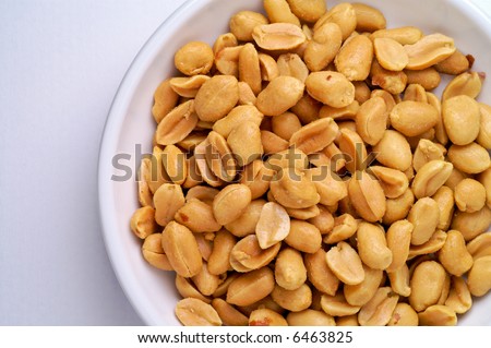 Peanuts in a dish from above over white