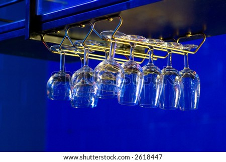 Wine Glasses Hanging Above Bar in Club Lit with Ultra-violet and Neon Lighting
