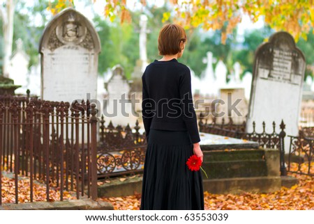 Mourning Woman at Cemetery with Red Flower