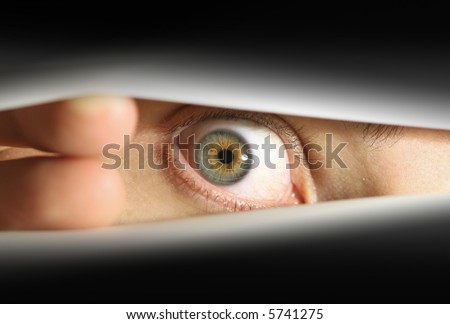 Male eye peering into envelope/package or peering through blinds